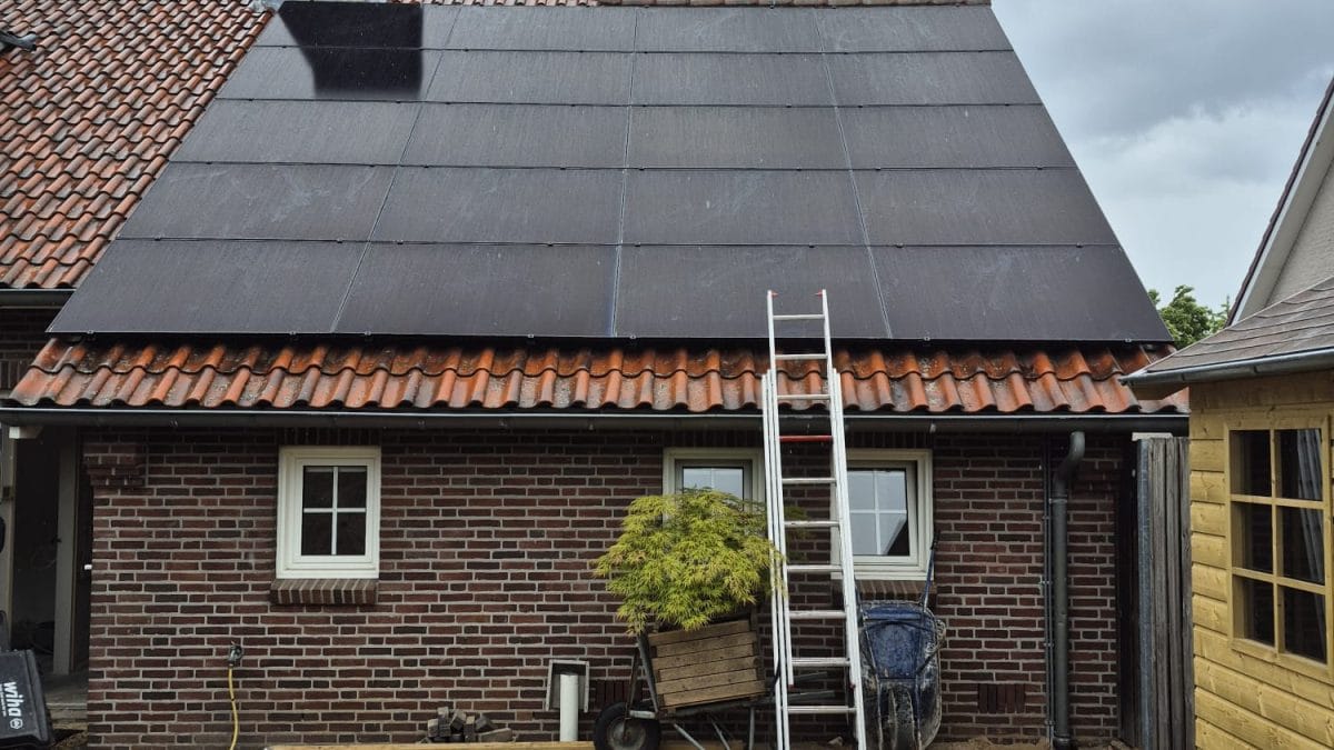 Zonnepanelen op rood pannendak van Nederlandse woning met ladder en voorbereidingen voor energieopslag